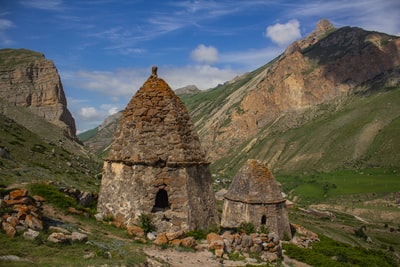 白天，在蓝天下的布朗山附近的绿色草地上建造灰色混凝土建筑